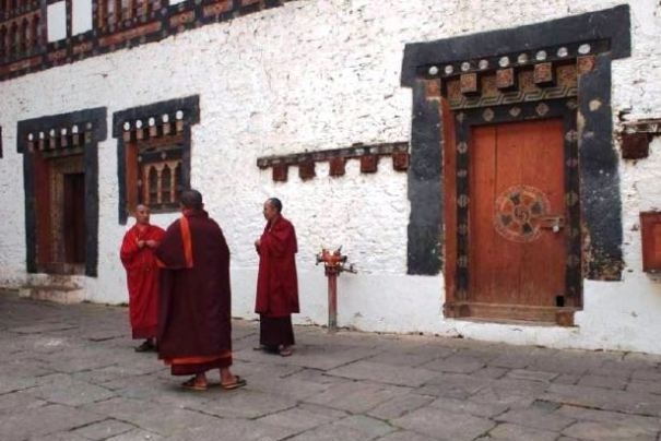 Mnisi na dziedzińcu dzongu w Bhutanie.